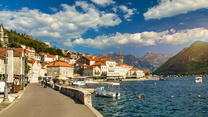 Obraz premium View of the historic town of Perast at famous Bay of Kotor on a beautiful sunny day with blue sky and clouds in summer, Montenegro. Historic city of Perast at Bay of Kotor in summer, Montenegro.