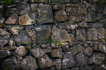 Granite stones of different shapes and colors. Wall cladding.