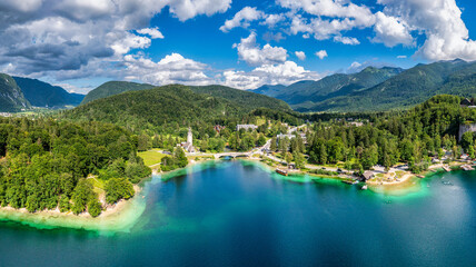 Aerial view of Bohinj lake in Julian Alps. Popular touristic destination in Slovenia. Bohinj Lake, Church of St John the Baptist. Triglav National Park, Julian Alps, Slovenia.