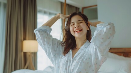 Asian beautiful girl in pajamas wake up in the morning with happiness. Attractive young woman smiling, feel happy and relax then stretching body after getting