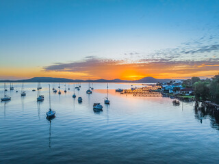 Sunrise over the water with boats and reflections
