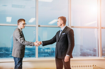 handshake of two male businessmen in a modern office