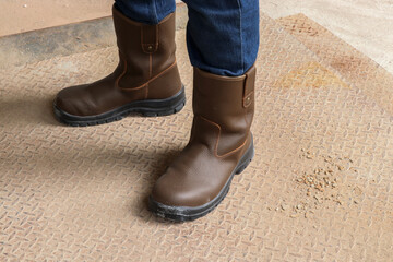Photo of brown leather safety boots worn by a construction worker to protect his feet from work accidents
