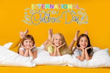 Cute little girls with pillows on color background