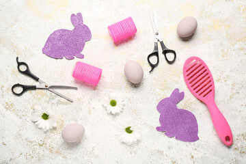 Hairdressing accessories with daisies, Easter eggs and paper bunnies on light grunge background