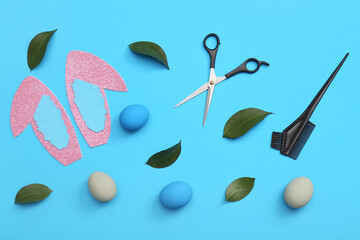 Paper bunny ears with Easter eggs, leaves and hairdressing scissors on blue background