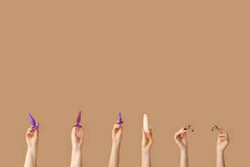 Female hands with different sex toys against color background