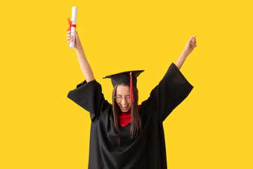 Cheerful female graduate diploma on yellow background