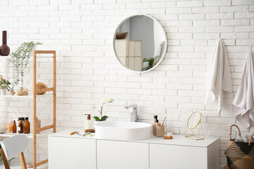 Interior of stylish bathroom with sink near white brick wall