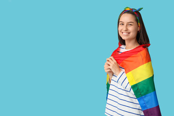 Beautiful young woman in hairscarf with LGBT flag on blue background