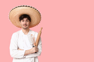 Young male chef with sombrero and cooking utensils on pink background