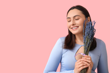 Beautiful young woman with bouquet of lavender flowers on pink background