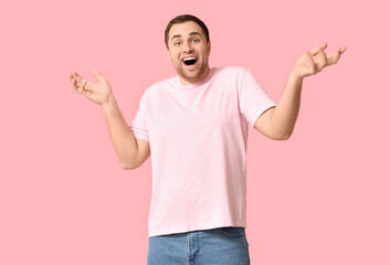 Surprised young man on pink background