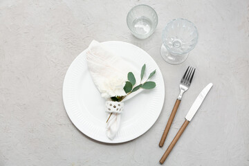 Table setting with beautiful flower and leaves on grey background