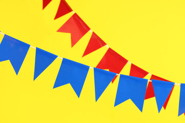 Bright flags for Festa Junina celebration on yellow background, closeup