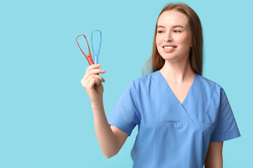 Female dentist with tongue scrapers on blue background