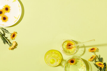 Against the pastel background, some laboratory glassware with liquid extracted from Calendula...