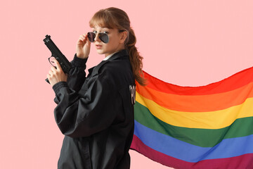 Female police officer with gun and LGBT flag on pink background