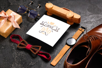 Gift box, paper with text I LOVE DAD and man's accessories on black background. Father's Day...