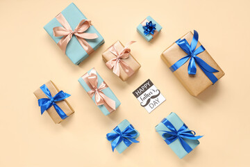 Gift boxes and greeting card with text HAPPY FATHER'S DAY on beige background. Top view