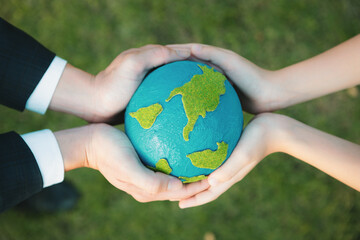 Top view businessman hand giving Earth globe to little boy as Earth day concept as corporate social responsible to contribute greener environmental protection for sustainable future generation. Gyre