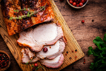 Baked festive pork butt or ham with herbs, spices and cranberries for sauce, served and sliced on...