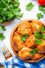 Meatballs with tomato sauce in bowl on white table background. Top view