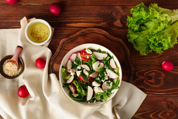 Composition with bowl of tasty salad and ingredients on wooden background