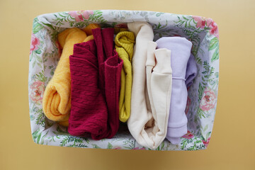 A rectangle violet basket of kid cloths on the table