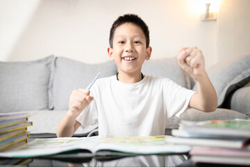 Happy asian boy raising hands to success,little child showing a quick-witted intelligence,smart...