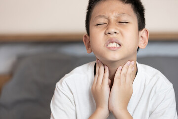 Asian child boy touching his neck,loss of the voice,hoarseness,voice is hoarse from Laryngitis or...