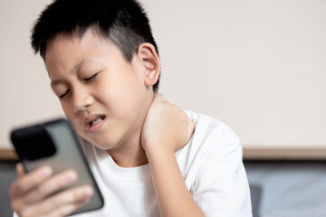 Asian boy looking at phone screen,tilting his head down for long time,Text Neck Syndrome,Smartphone...