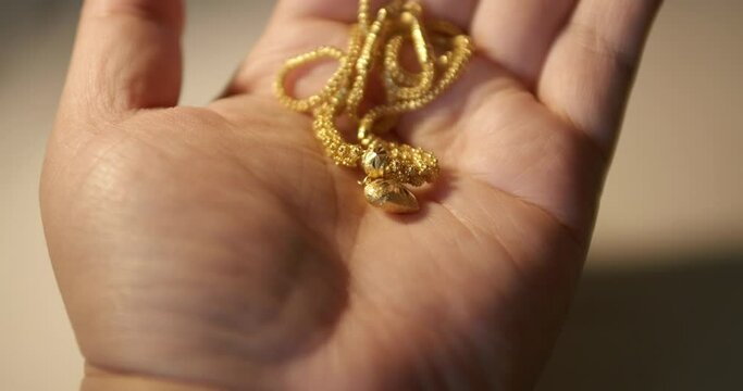 Gold Wedding Necklace in hand. Jewelry for Weddings and engagements.