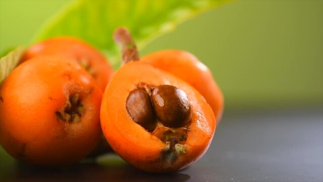 Loquat fruit or Japanese medlars, Nispero, Eriobotrya japonica fresh ripe bio vegetarian food, medlar berries. Close up, slow motion