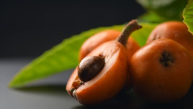 Loquat fruit or Japanese medlars, Nispero, Eriobotrya japonica fresh ripe bio vegetarian food, medlar berries. Close up, slow motion. 