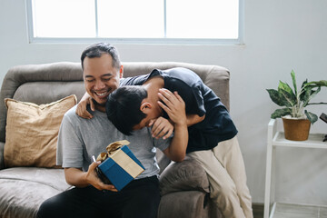 Happy Father's Day. Father Receive a Gift From Lovely Son at Home. Dad Embracing Son. 