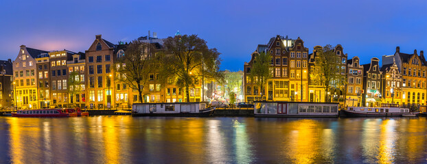 Amsterdam Netherlands, night panorama city skyline at canal waterfront