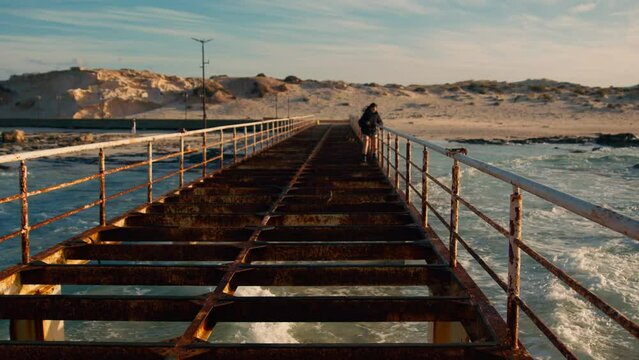 tourist walking on bridge above  lagoon in Marsa Matrouh reaching Cleopatra beach in Egypt