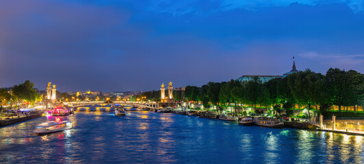 Paris France, panorama city skyline night at Seine River with Pont Alexandre III bridge and Grand...