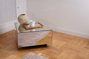 Modern mirror table with a cup on a glass tray