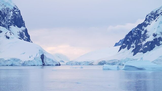 Antarctica Mountains and Glacier Landscape Scenery at Sunset, Lemaire Channel Passage Ocean Seascape of Sea and Ice in Icy Winter Scene on the Beautiful Calm Antarctic Peninsula Coast