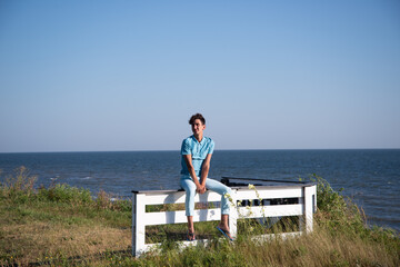 Fototapeta premium A young attractive guy is walking on the beach.