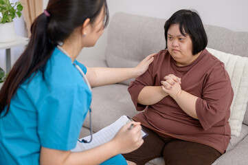 Asian female nurse or therapist Providing counseling to disabled Asian women with Down syndrome....