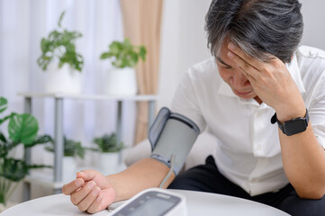 Asian senior man disappointed and sad With the test results for diabetes and high blood pressure,...