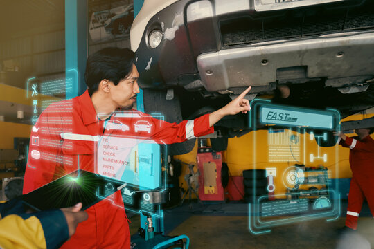 Car mechanic inspects car using technology and computer show resault at virtual screen.