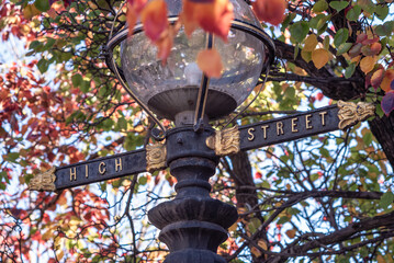A lamp post in Northcote, Victoria, Australia featuring a glass dome light, and the High Street name in gold lettering.