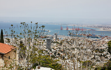 Seaport in the city of Haifa, panorama of the port and city buildings against the background of a blue sky with clouds