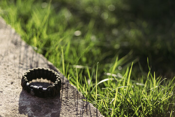 a hiking bracelet lies on the grass