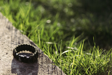 a hiking bracelet lies on the grass