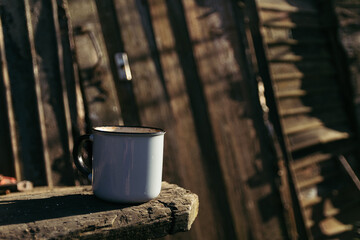 a cup of hot drink on a wooden table on a sunny day
